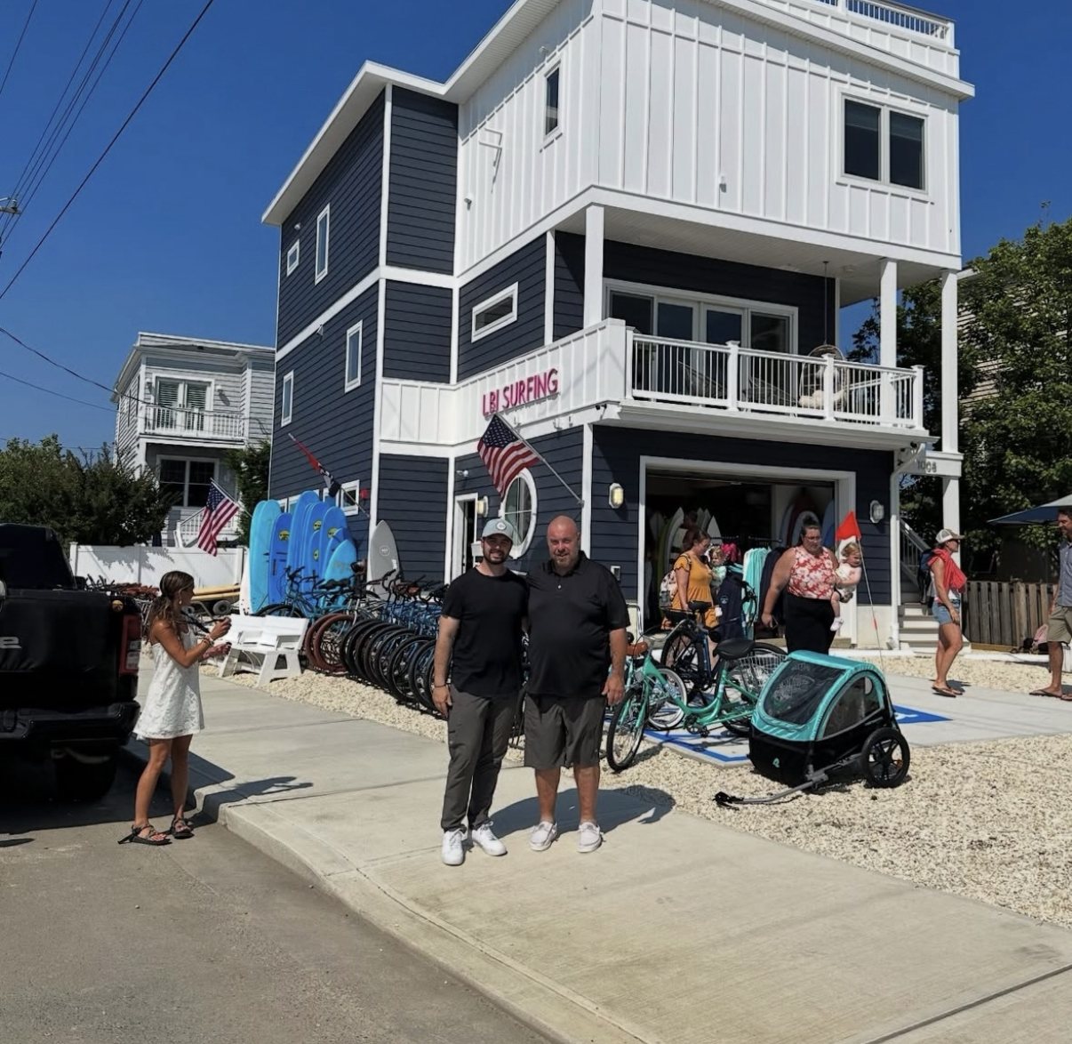 Aiden Hosszu and his father in front of a finished shore building